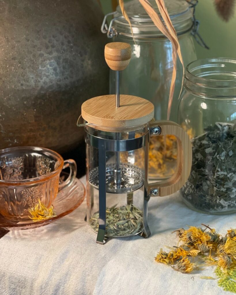 A tea press with herbs.